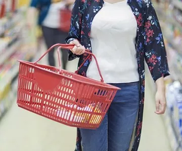 Mulher carregando uma cesta de compras